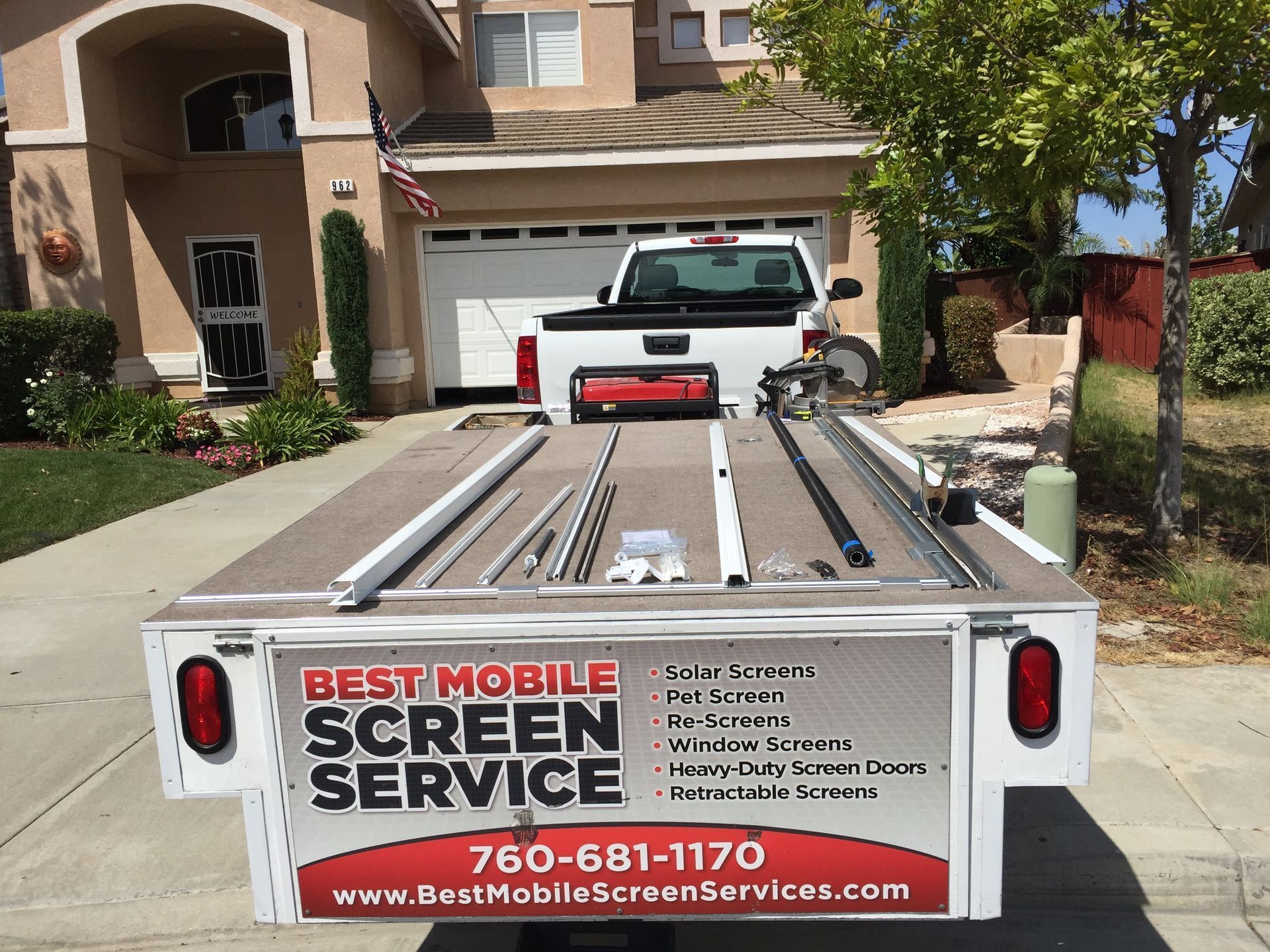 A best mobile screen service trailer is parked in front of a house