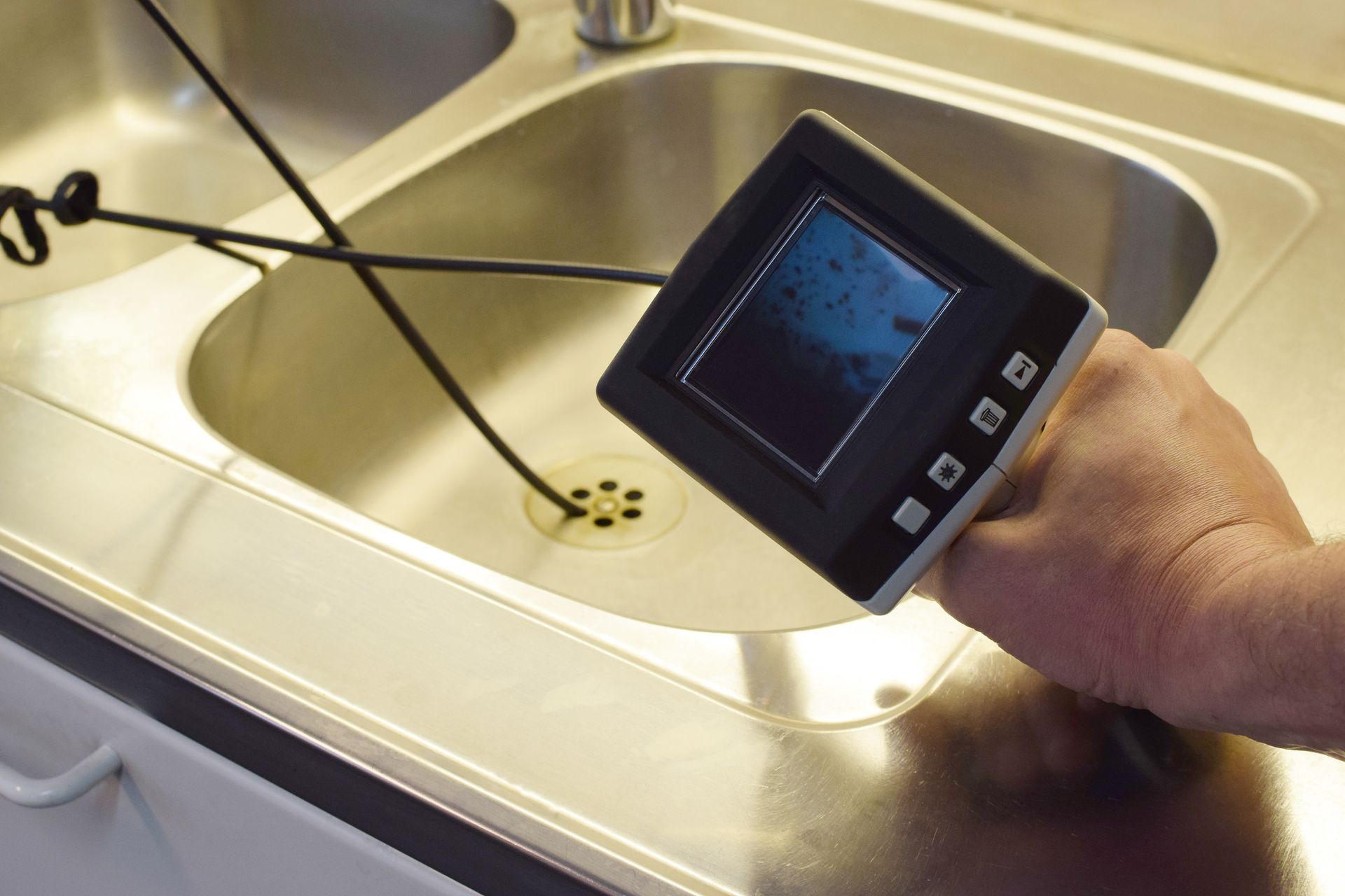 a person is holding a small device over a sink