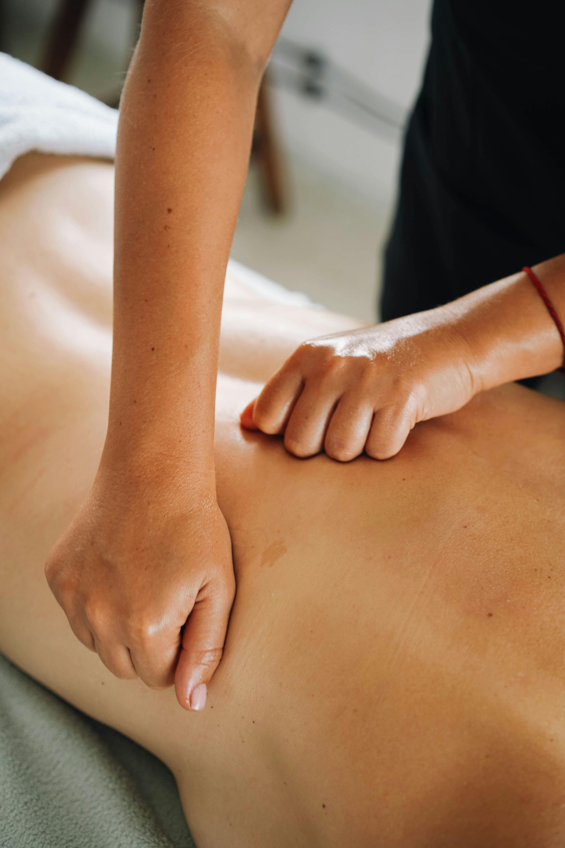 Massage Therapist's Hands Pressing on a Person's Bare Back — Leela Thai Massage & Spa in Newtown, QLD