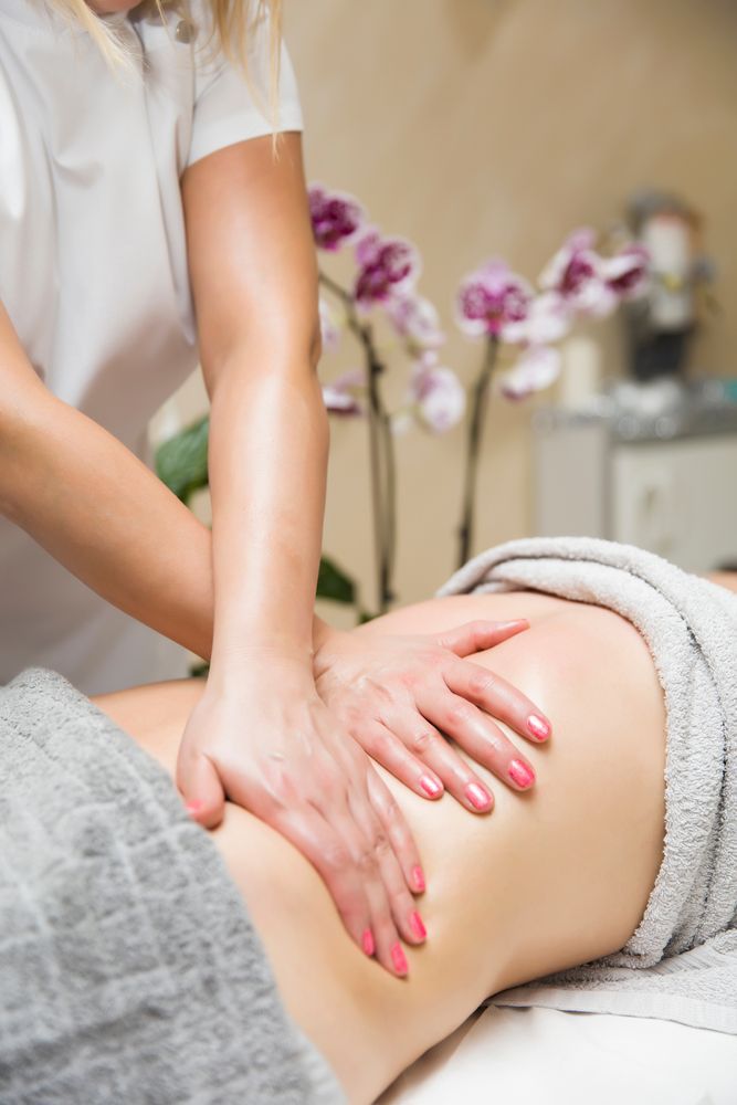 Hands Massaging a Person's Lower Back, Covered With a Gray Towel — Leela Thai Massage & Spa in Newtown, QLD