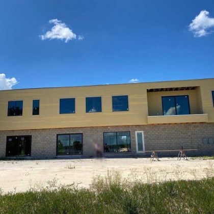 A large yellow building with a lot of windows and a blue sky in the background.