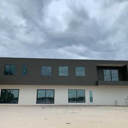 A large building with a lot of windows and a cloudy sky in the background.
