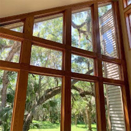 A room with a lot of windows and trees in the background.