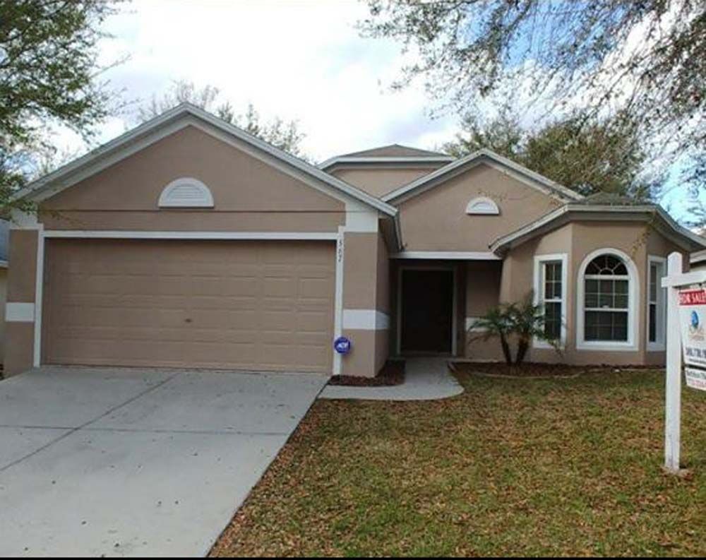 A house with a for sale sign in front of it