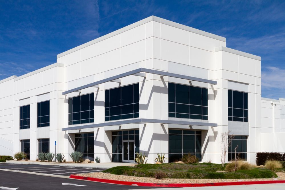 A large white building with a lot of windows and a red curb.