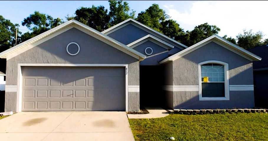 A gray house with a garage door and a window