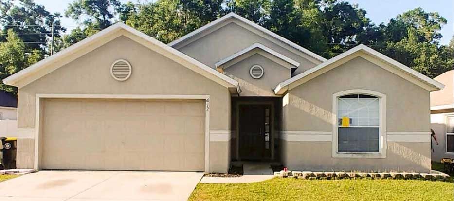 The front of a house with a garage door and a window.