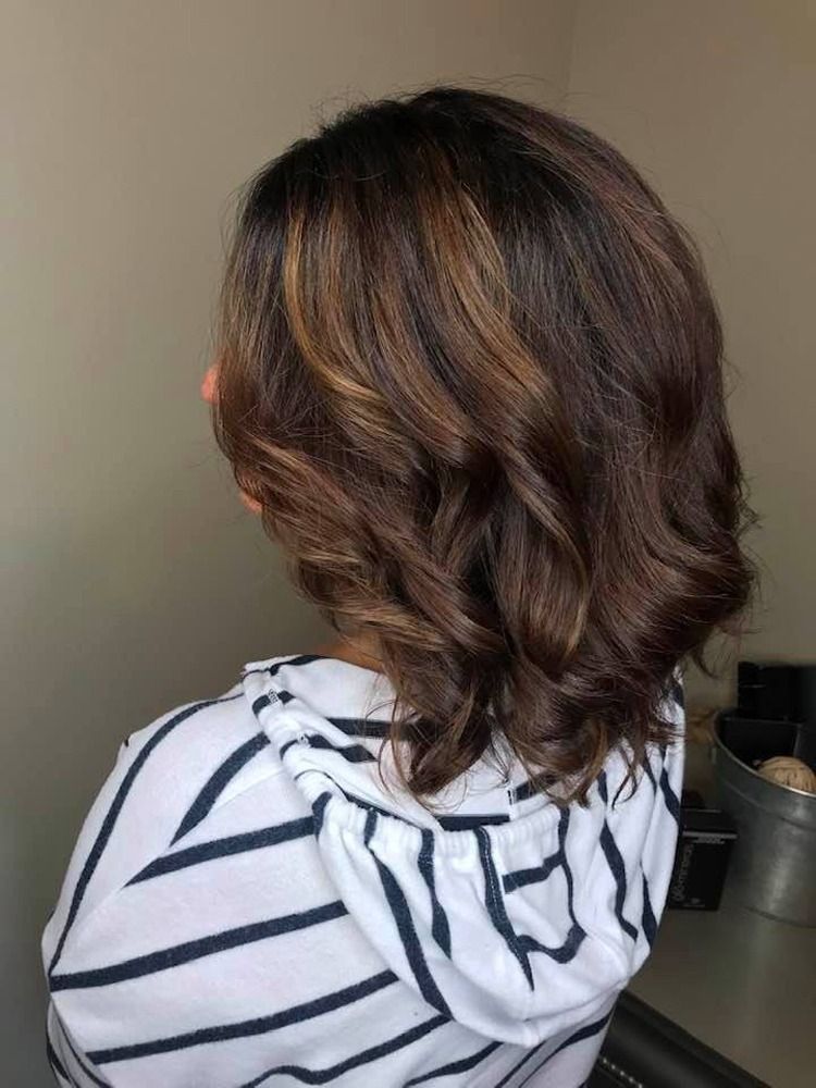 A woman with short brown hair is wearing a striped shirt.