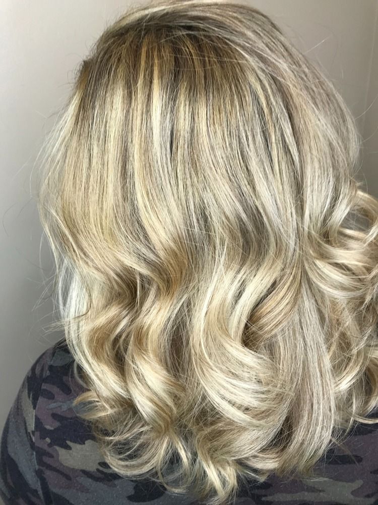 A woman with blonde hair is wearing a camouflage shirt.