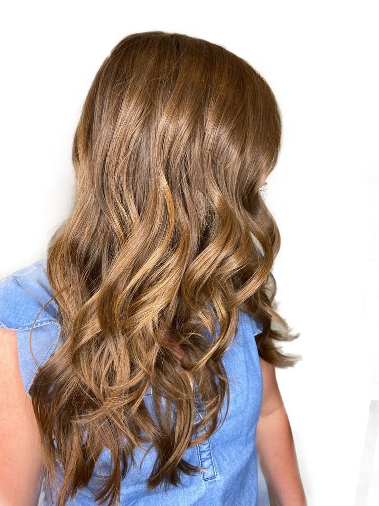 A woman with long brown hair is wearing a blue shirt.