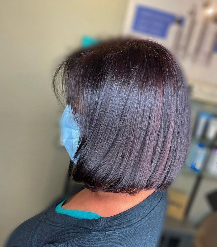 A woman with dark hair is wearing a blue mask.