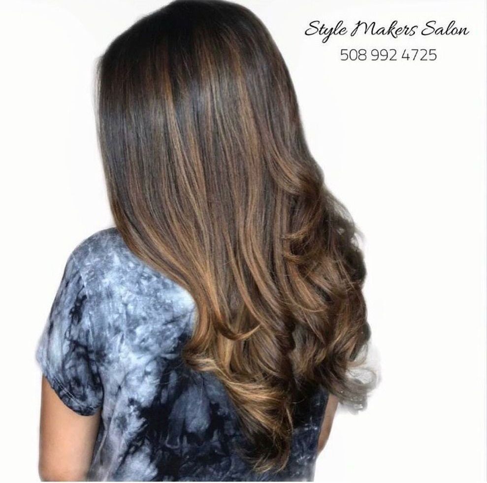 A woman with long brown hair is wearing a tie dye shirt