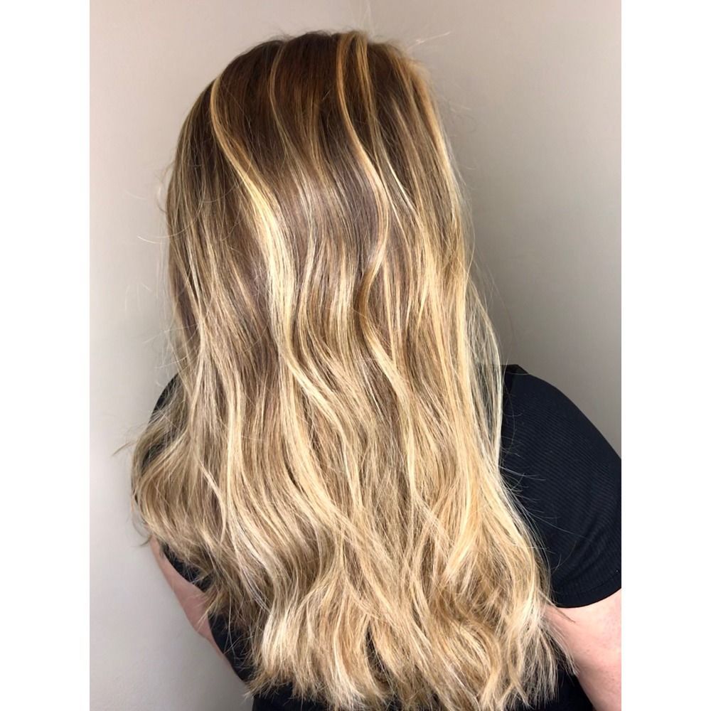 A woman with long blonde hair is wearing a black shirt.