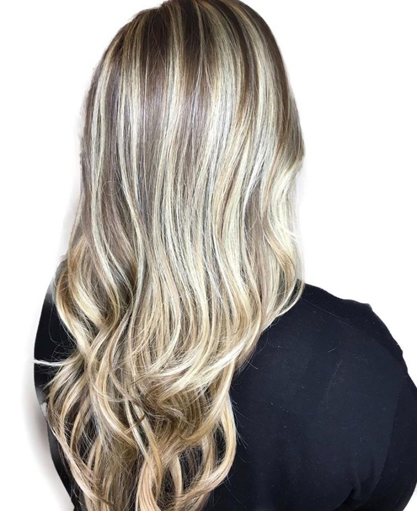 A woman with long blonde hair is wearing a black shirt.