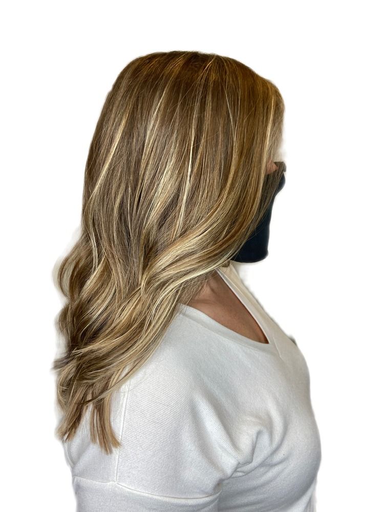 A woman wearing a white shirt and a black mask has long blonde hair.