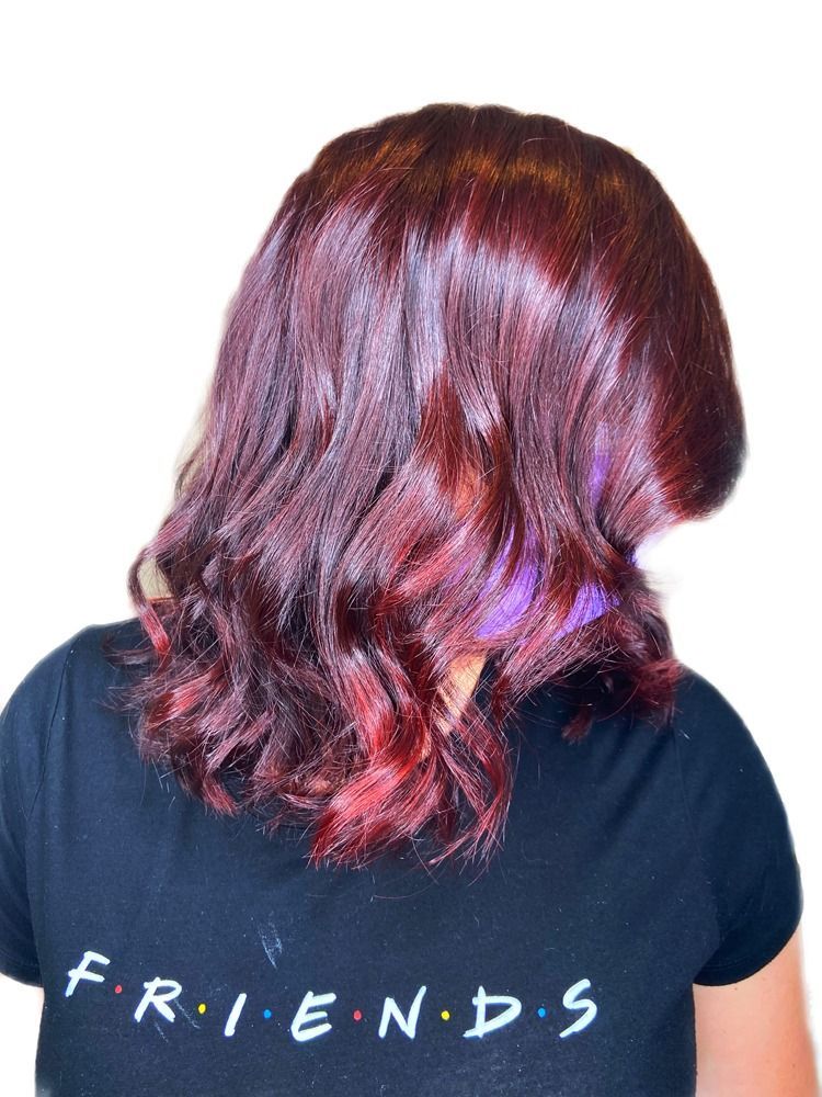 A woman with red hair is wearing a friends shirt