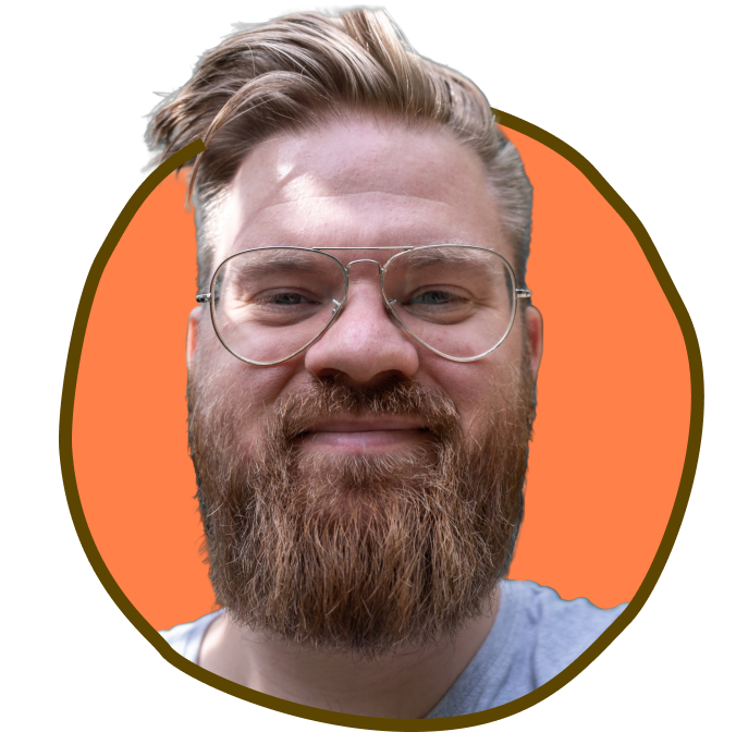 Mand med skæg og briller foran en orange baggrund.