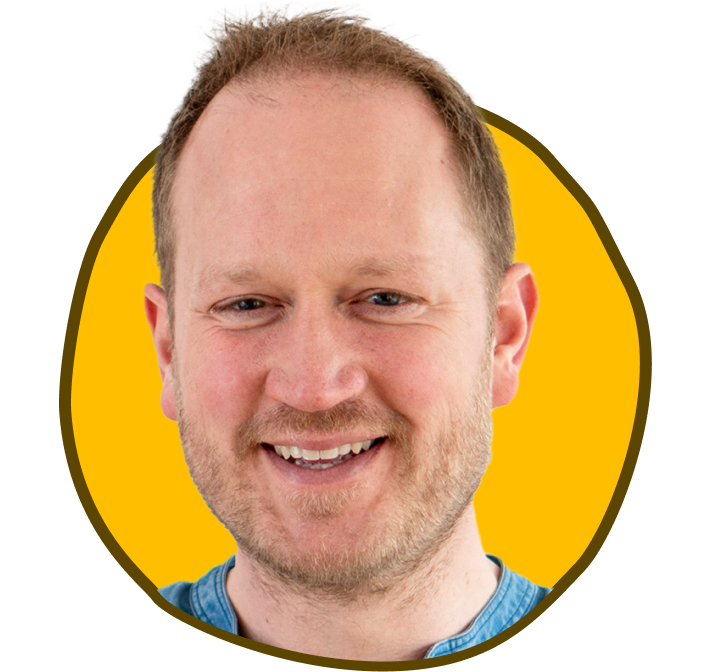 Smilende mand i en blå skjorte inden for en gul og brun kant.