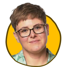 Person med kort brunt hår og briller, smilende, inde i en gul cirkel.