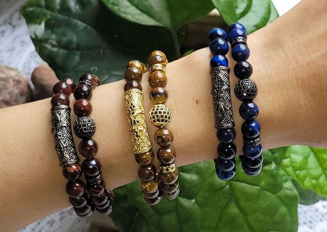 A person is wearing three bracelets on their wrist.