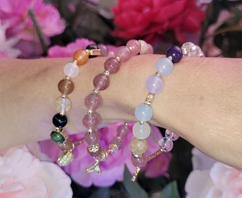 A person is wearing three bracelets on their wrist.