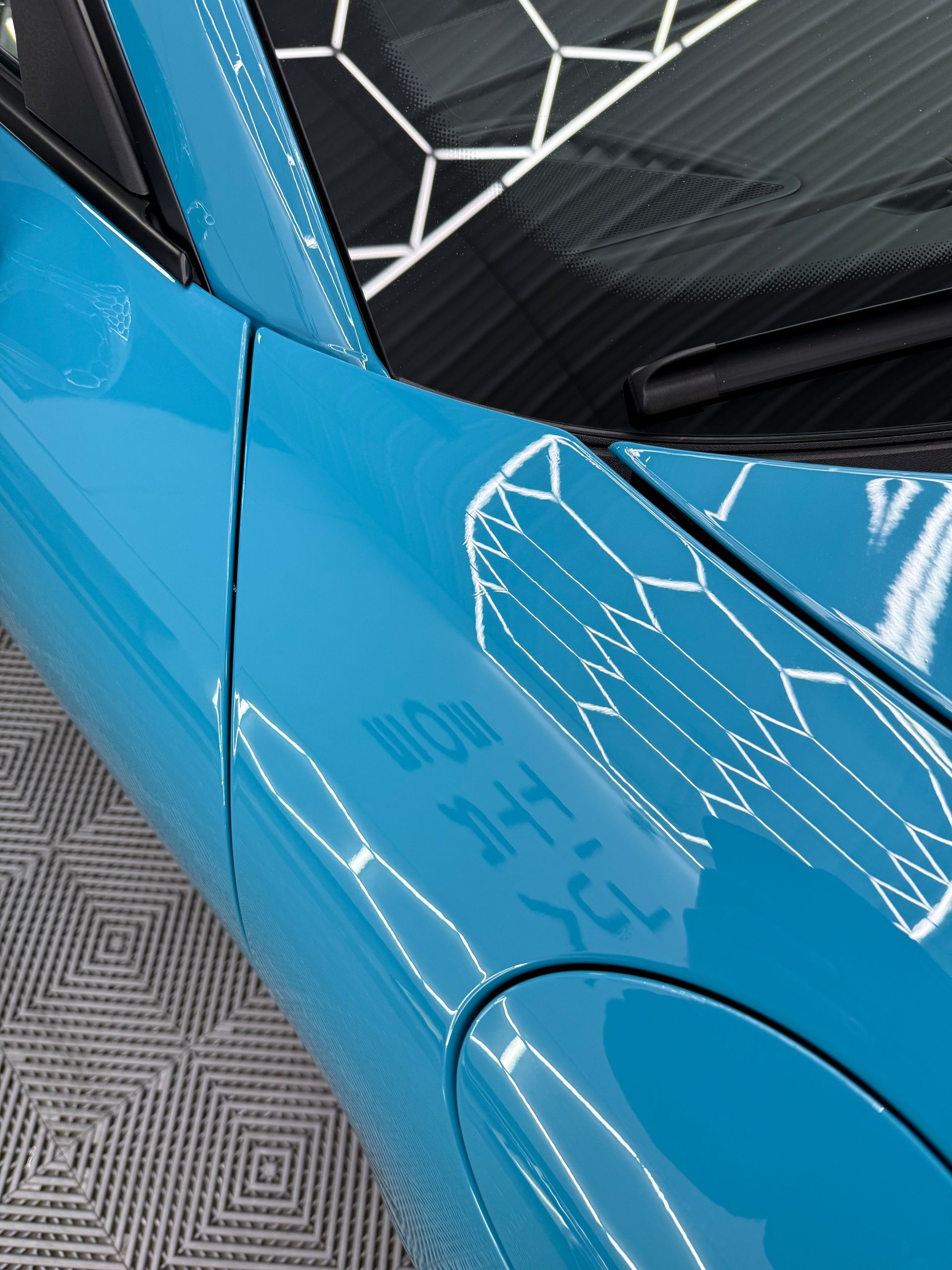 A close up of a blue car with the word why written on it