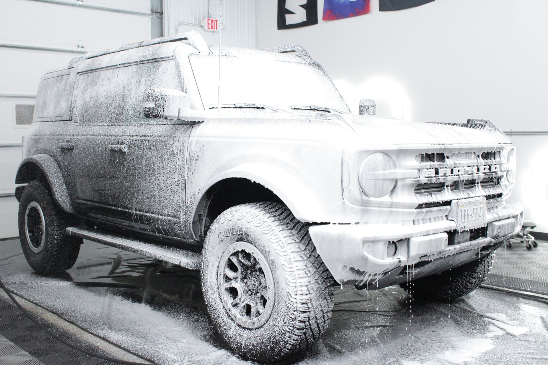 A man is applying ceramic coating to a black car.