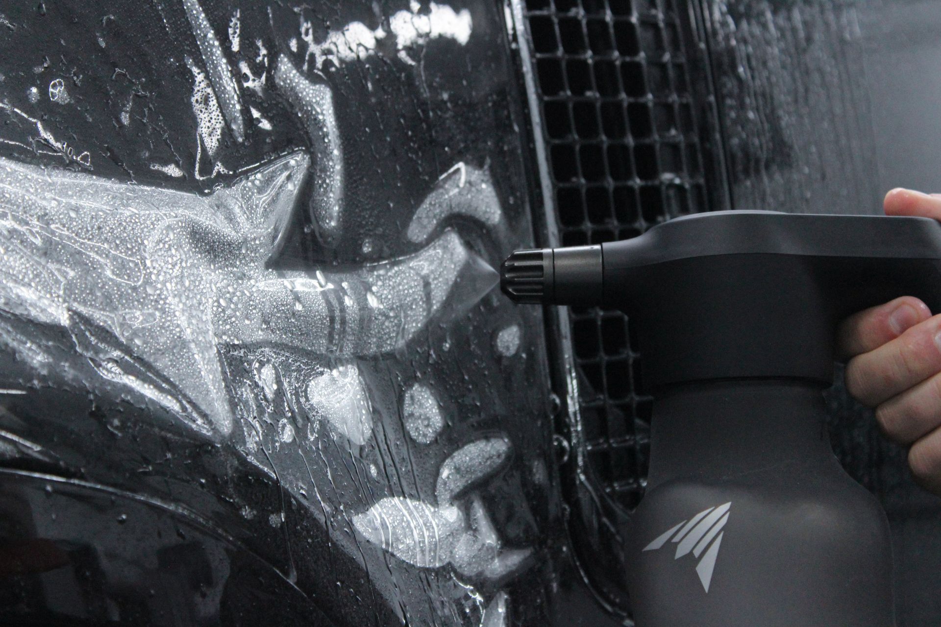 A person is cleaning a car with a spray bottle.