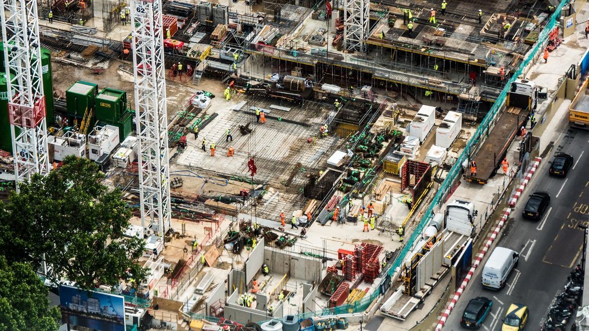 an aerial view of a construction site with a lot of people and trucks .