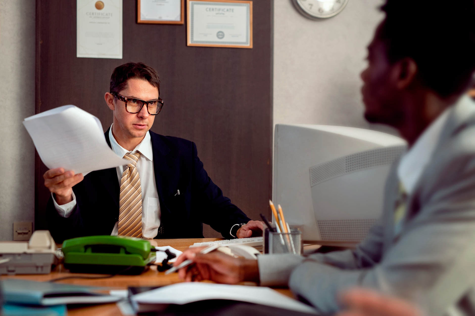 “Attorney reviewing legal documents with a client during an office consultation meeting.”