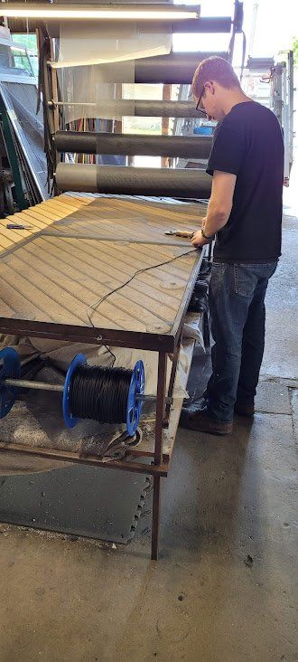 A man is measuring a piece of wood on a table.