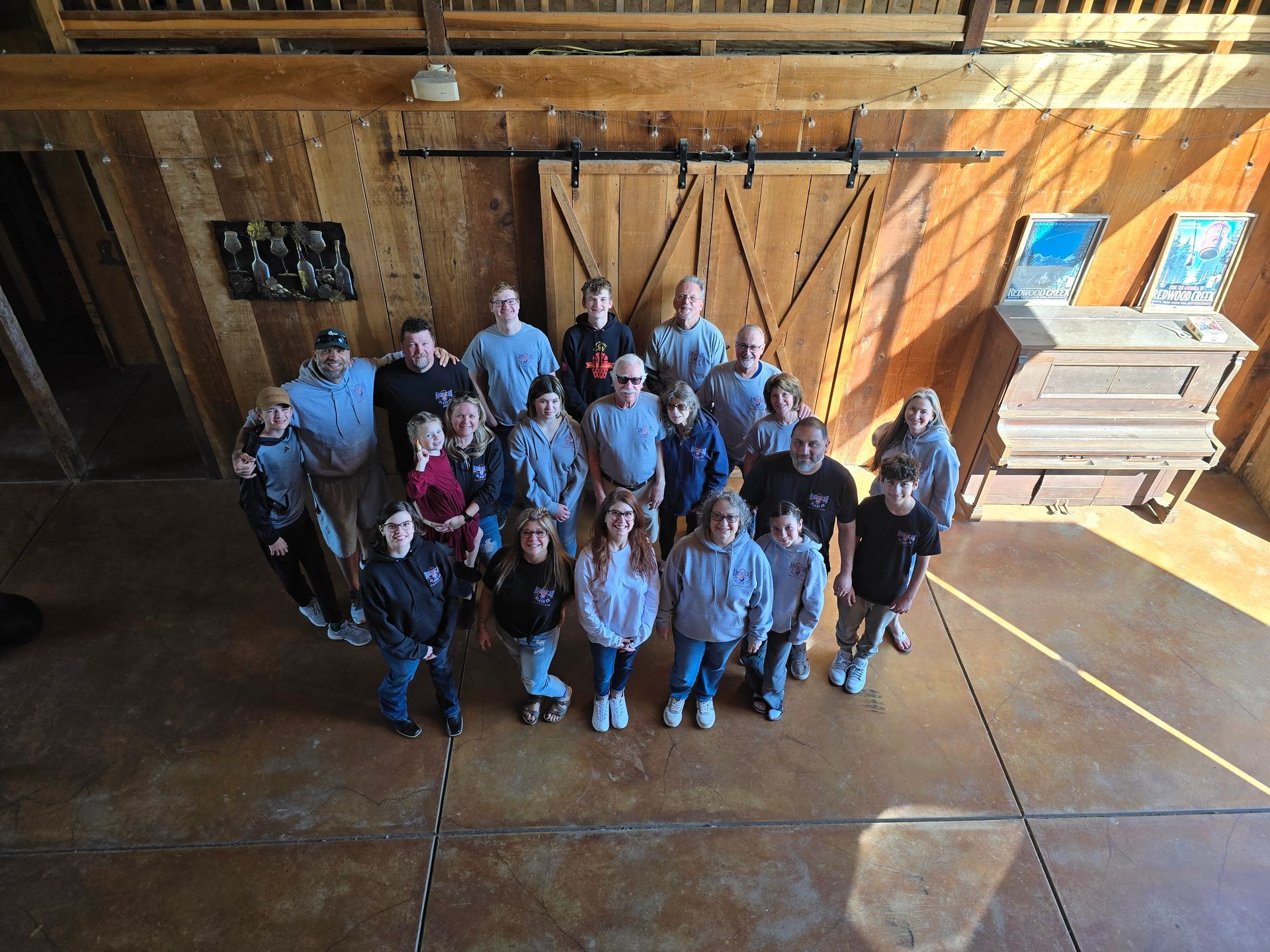 A group of people are posing for a picture in a barn.