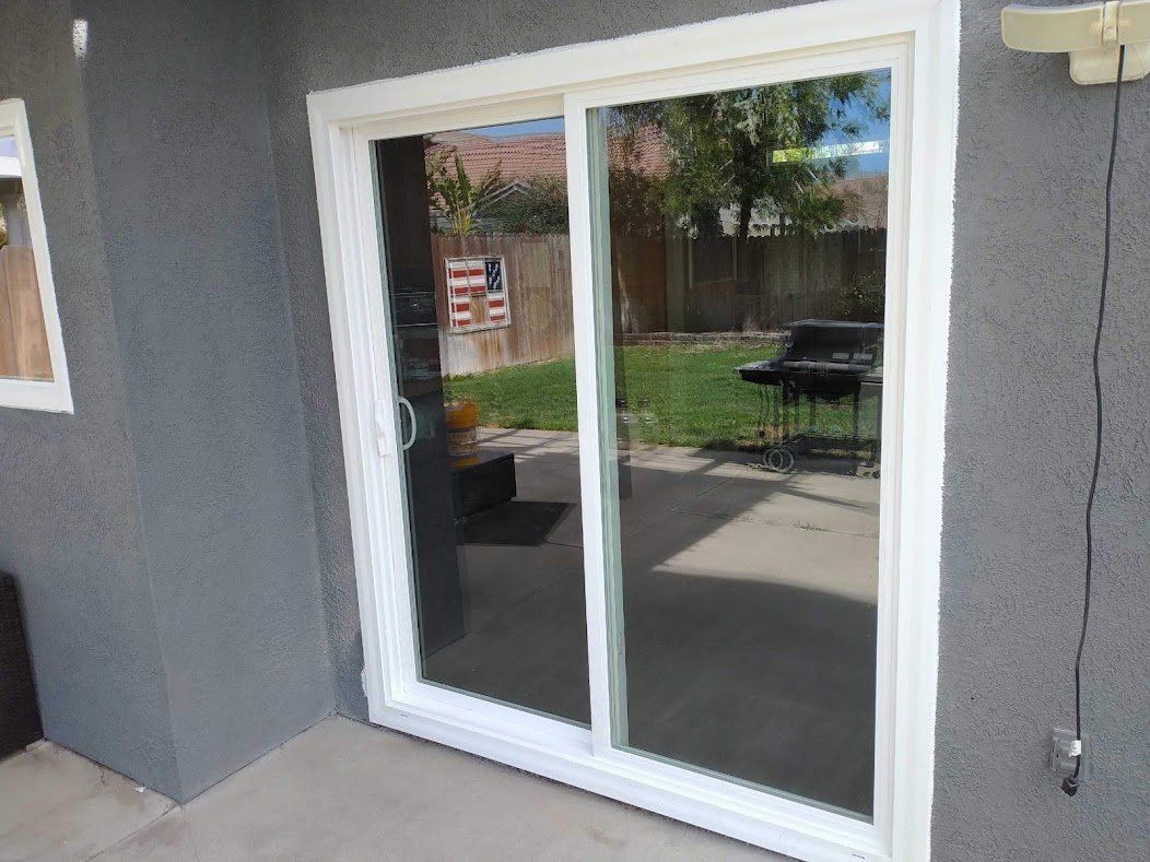 A white sliding glass door is open to a patio.