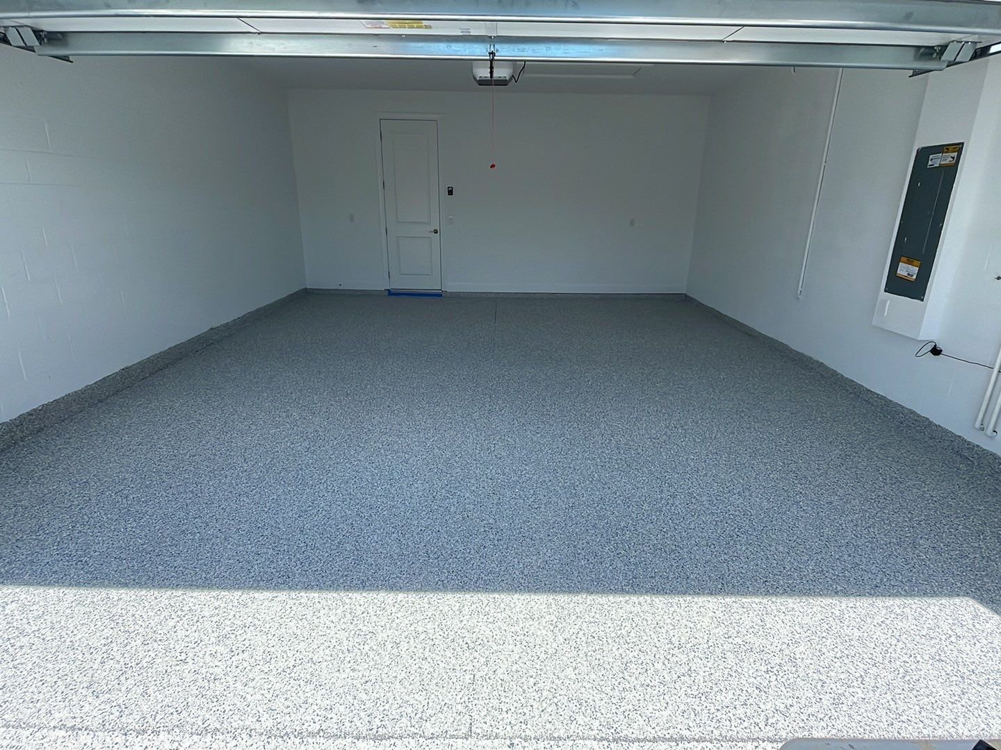 Interior of garage with concrete coating on floor and baseboard 