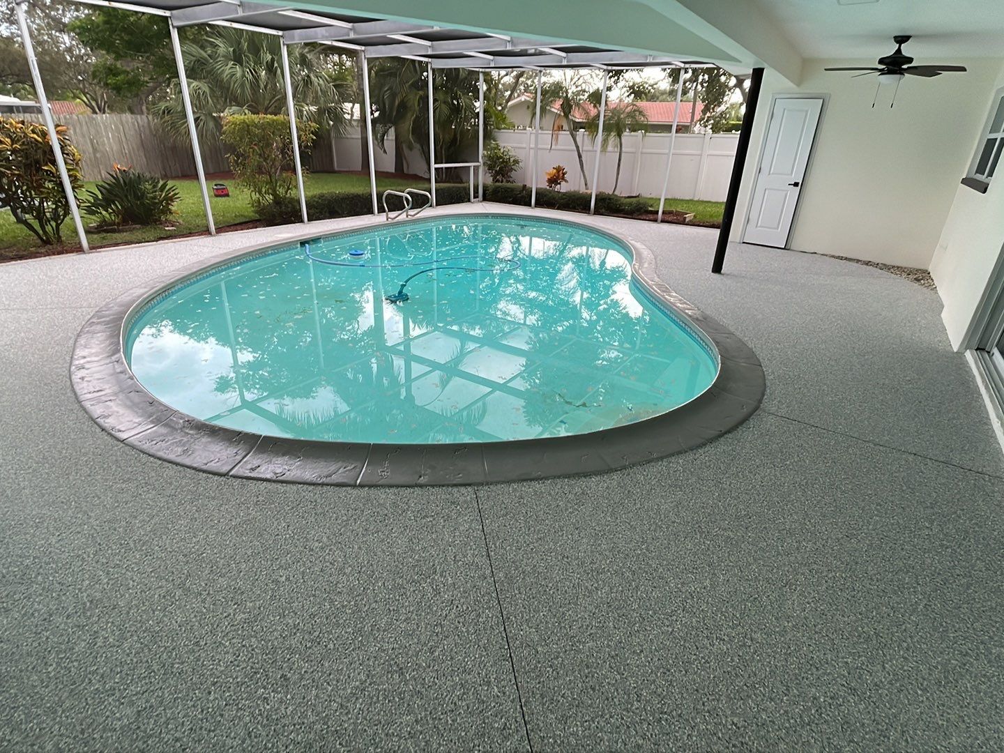 Concrete pool deck after pitting has been filled and new concrete coating applied