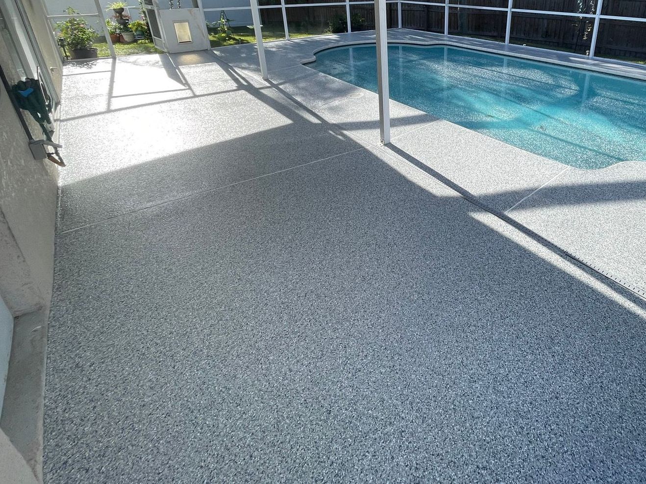 Beautiful cool-toned pool deck after cracks were mended and new concrete coating applied