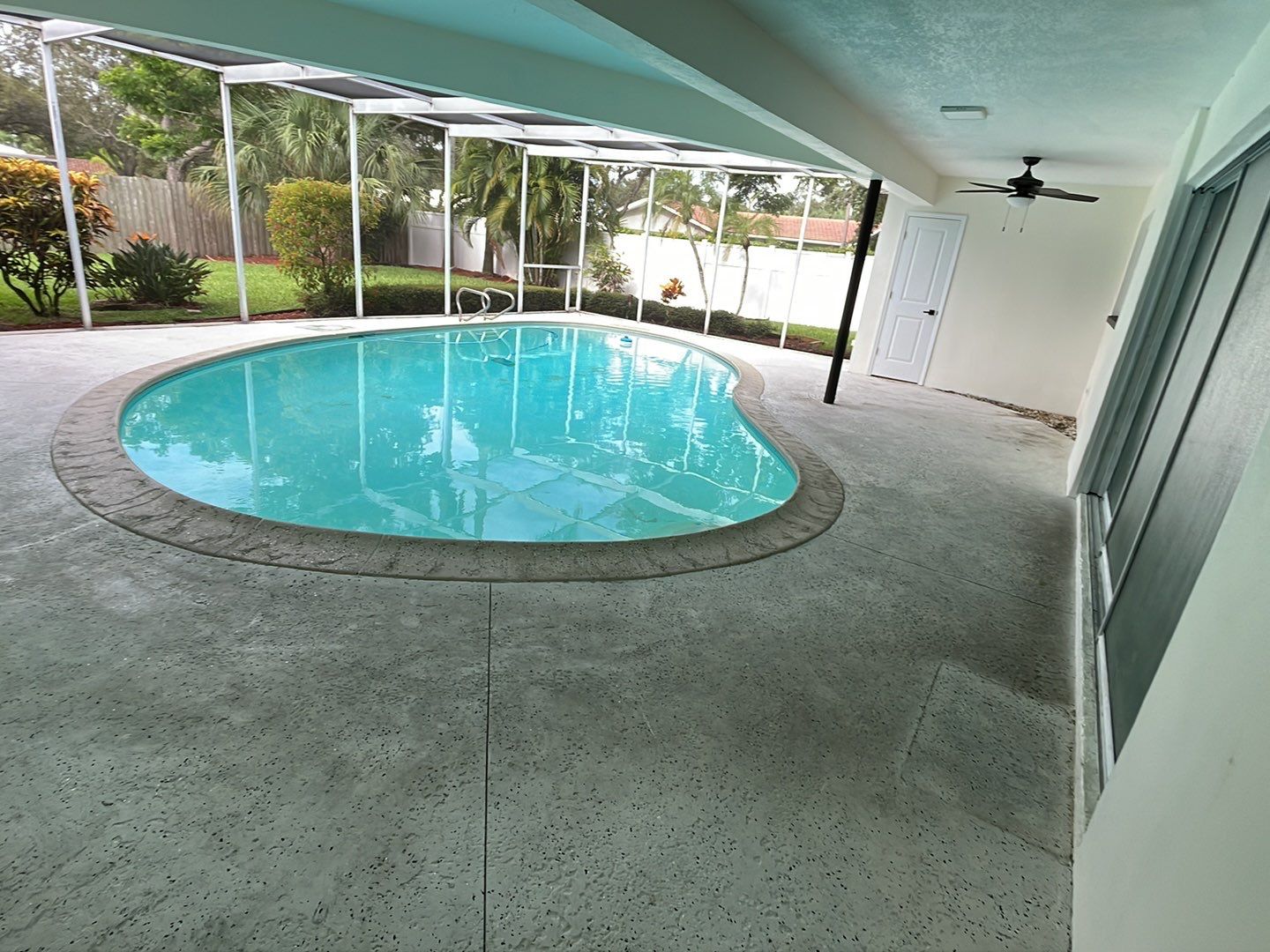 Bare concrete pool deck with stains and pitting