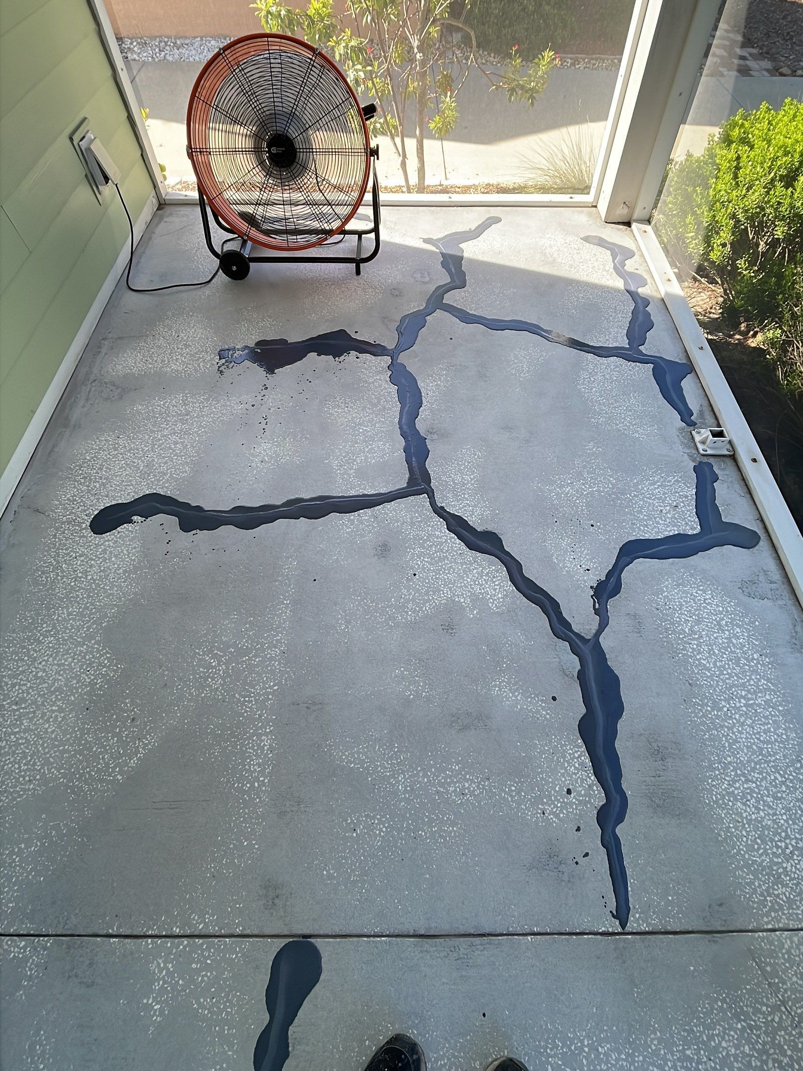 Bare concrete patio with cracks mended and filled in preparation for new concrete coating