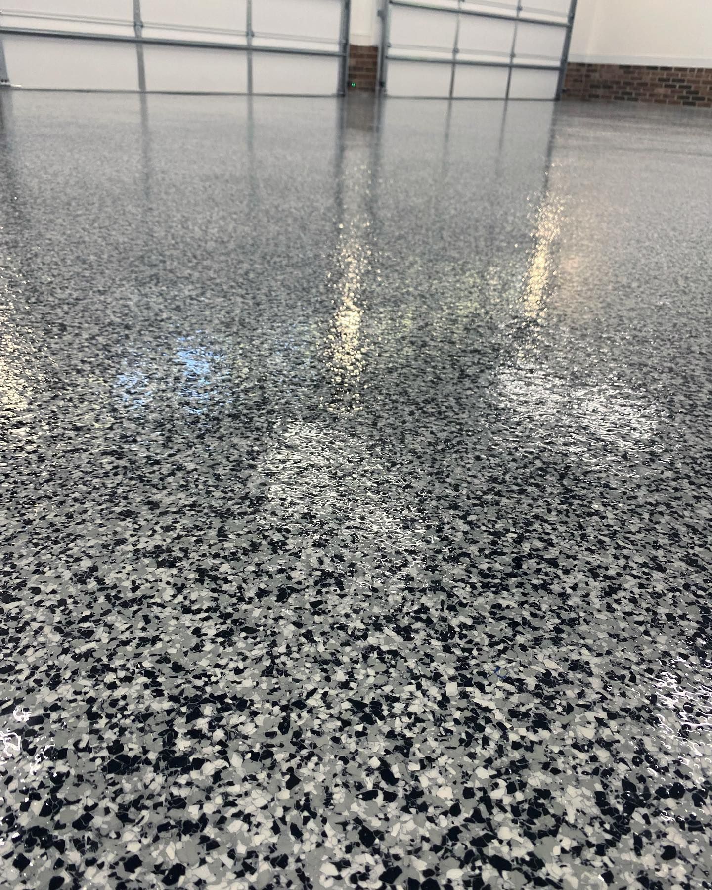 Gleaming black, grey and white concrete coating in a clean and empty garage