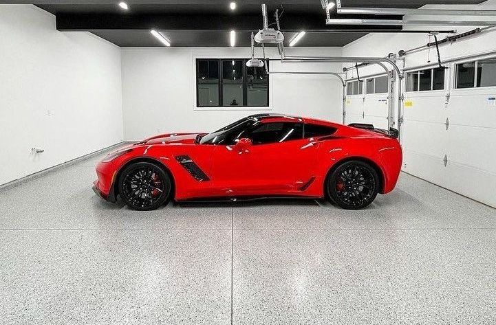 A neutral concrete coating on the floor of a garage storing red sports car