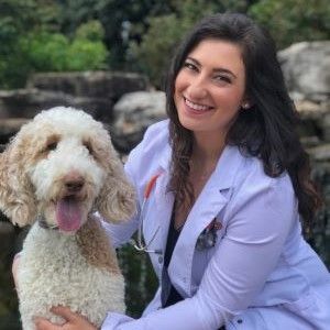 a woman in a white jacket is smiling for the camera .