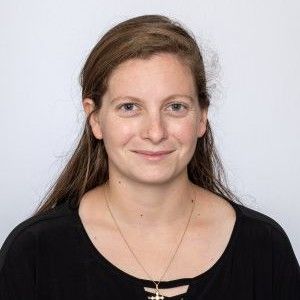 a woman is sitting on a log with two dogs .