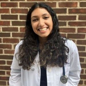 a woman in a white jacket is smiling for the camera .