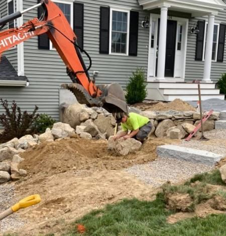 Sturdy retaining wall made of concrete blocks, providing structural support and preventing soil erosion in a landscaped garden.