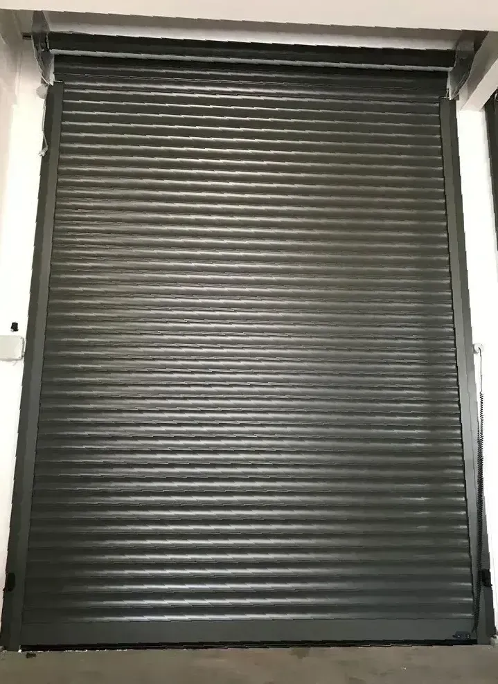 Dark gray closed metal rolling shutter in an indoor setting.