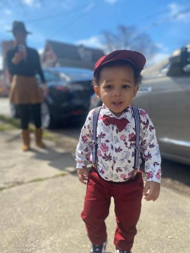 image of a toddler dressed up in suspenders and a bow tie at an Our Mommie Village Meetup