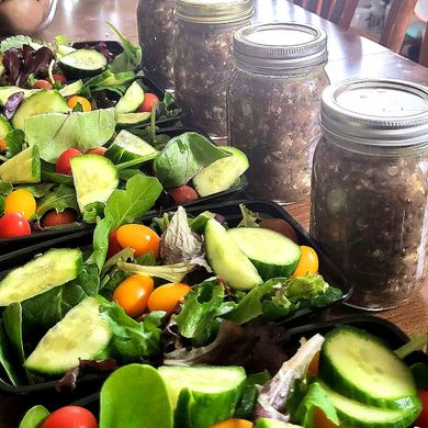 Prepared meals of salad and jars of lentils on a table