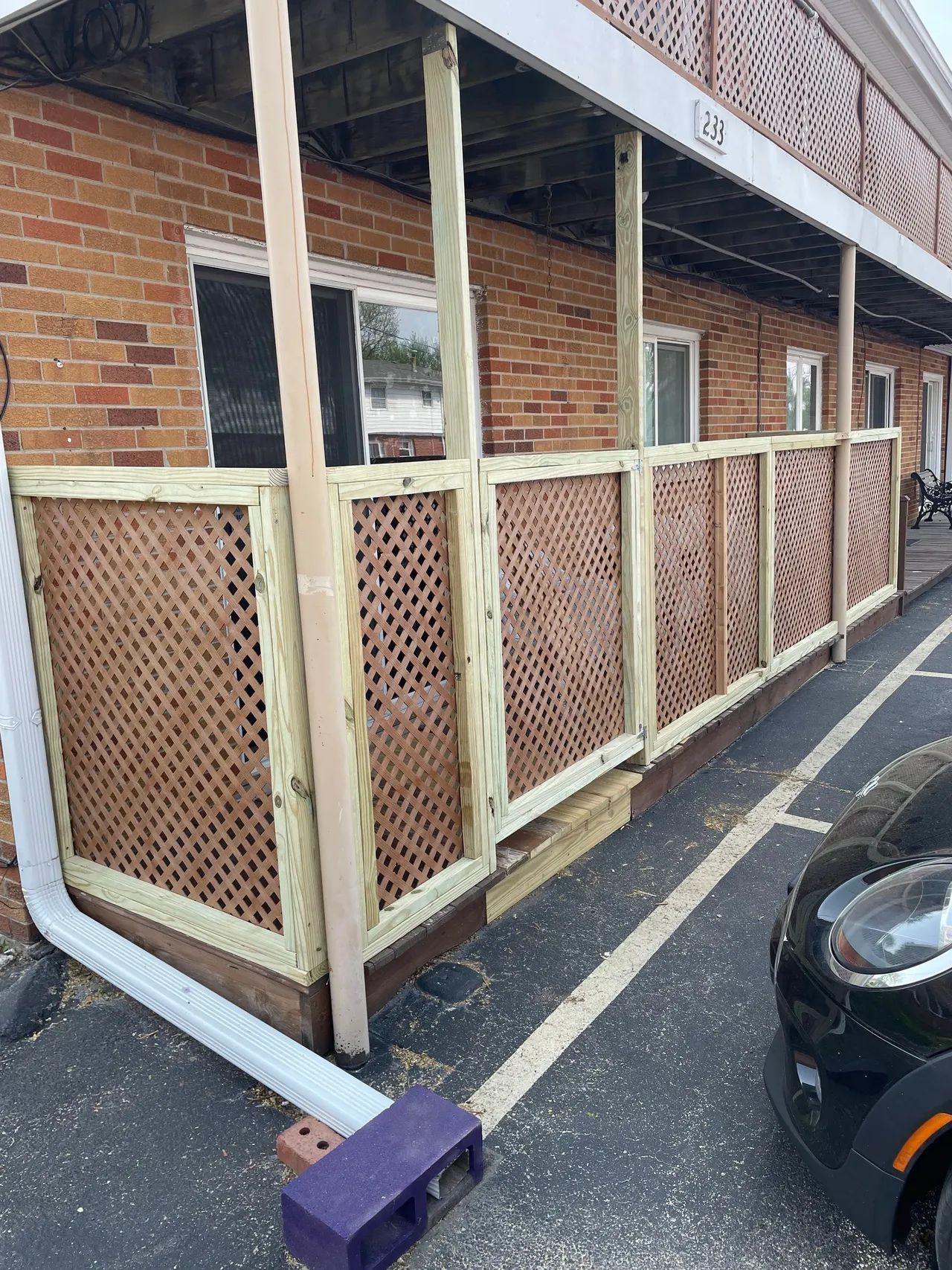 Wooden fence with lattice panels on a porch. Professional fence repair services and fence installation handyman work.