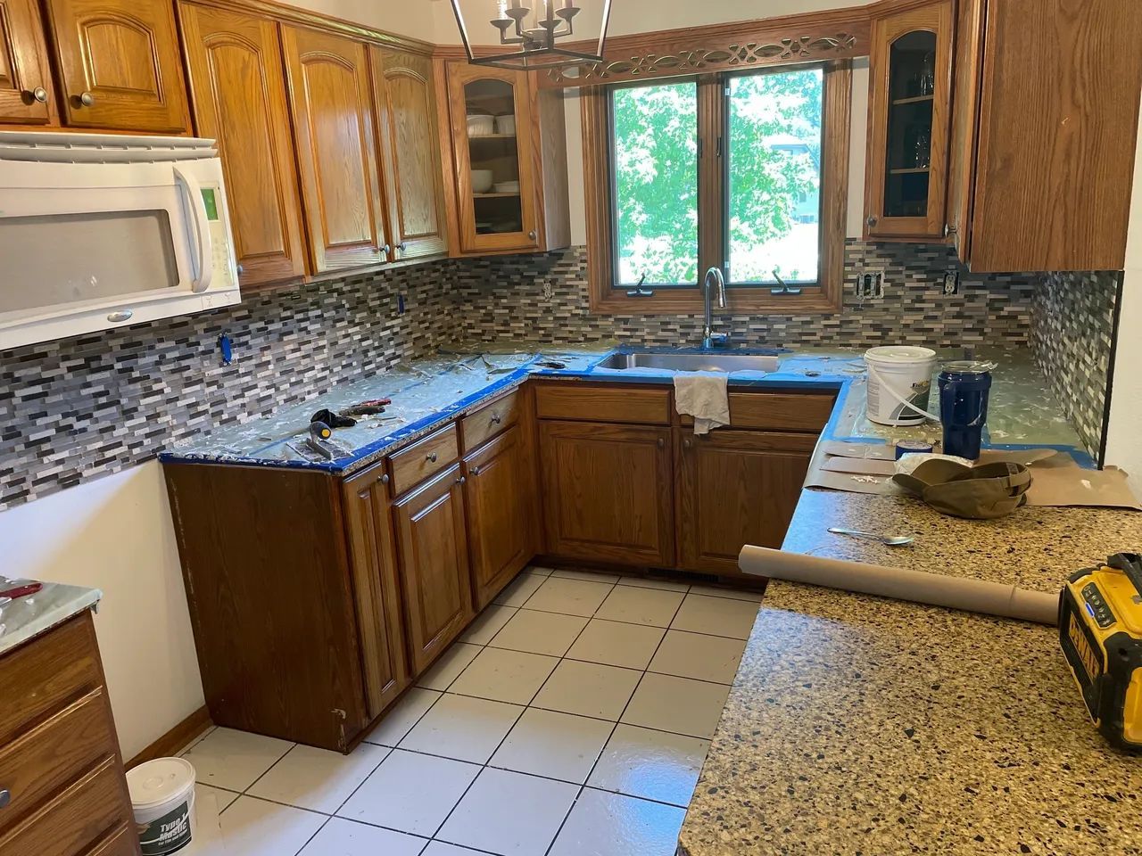 Kitchen remodel with tile backsplash and granite countertops. Expert home remodeling services and flooring installation.