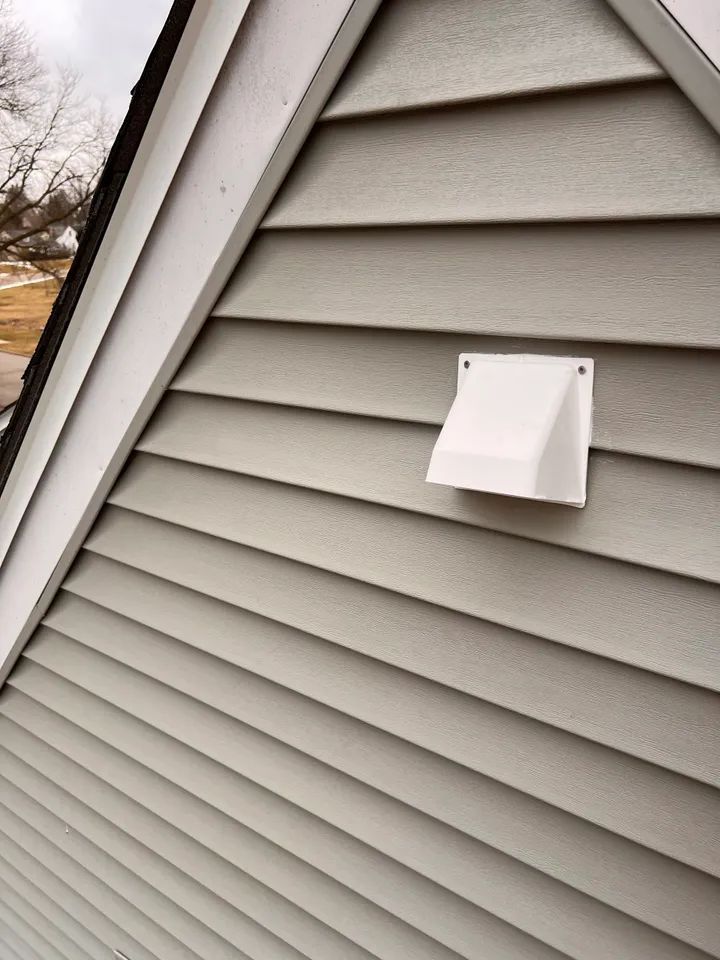 Exterior siding with a new vent on a gable wall. Professional exterior siding repair and exterior siding contractor work.